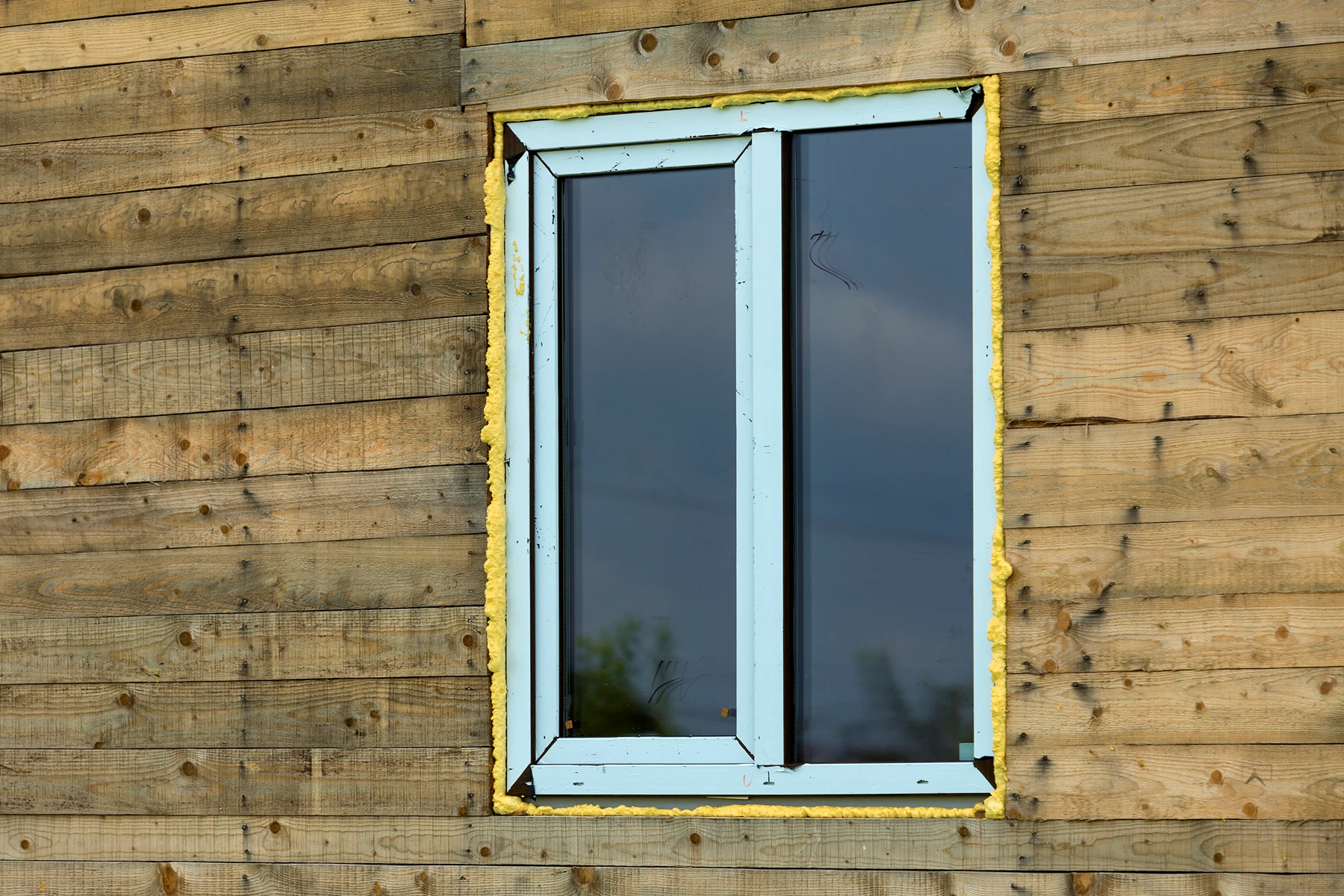 Fensterinstallation in einer Holzfassade mit Isolierung