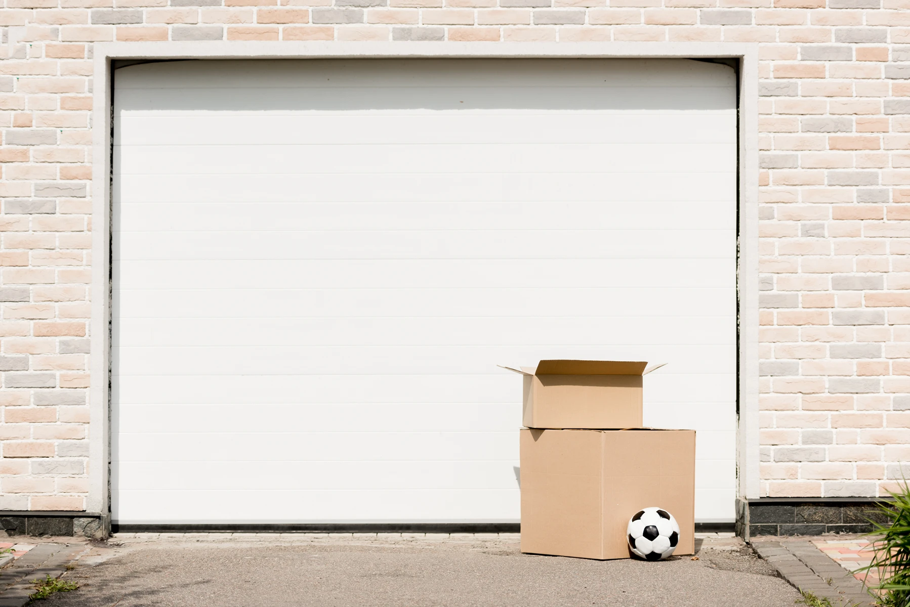 Garagentor mit Kartons und einem Fußball im Vordergrund