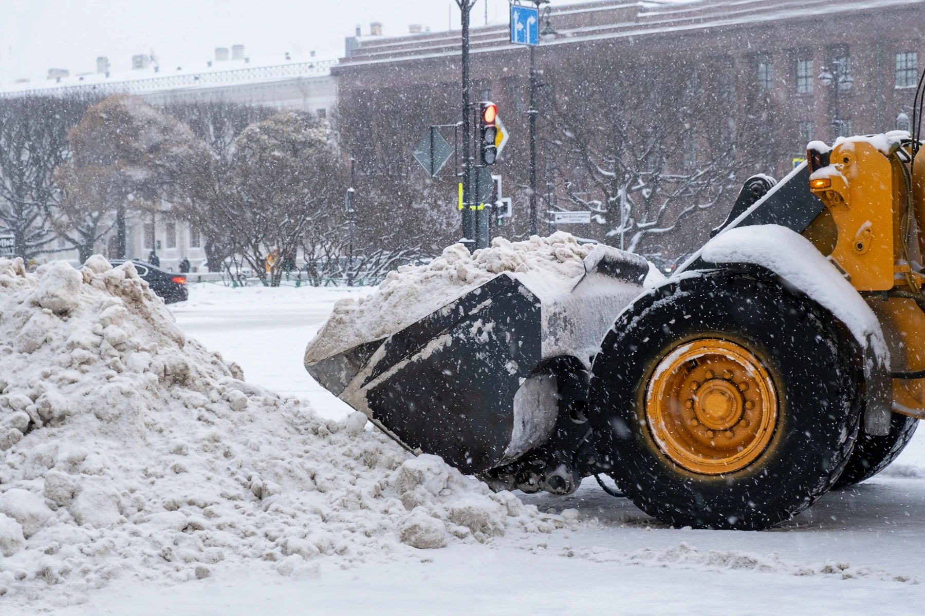 Schnee räumen mit einem modernen Schneepflug in einer winterlichen Stadtlandschaft