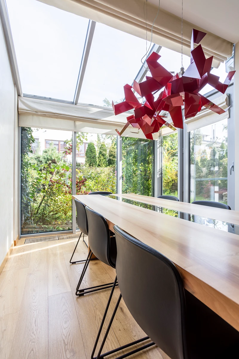 Moderne Esszimmer mit Glasdach und stilvollem roten Leuchten
