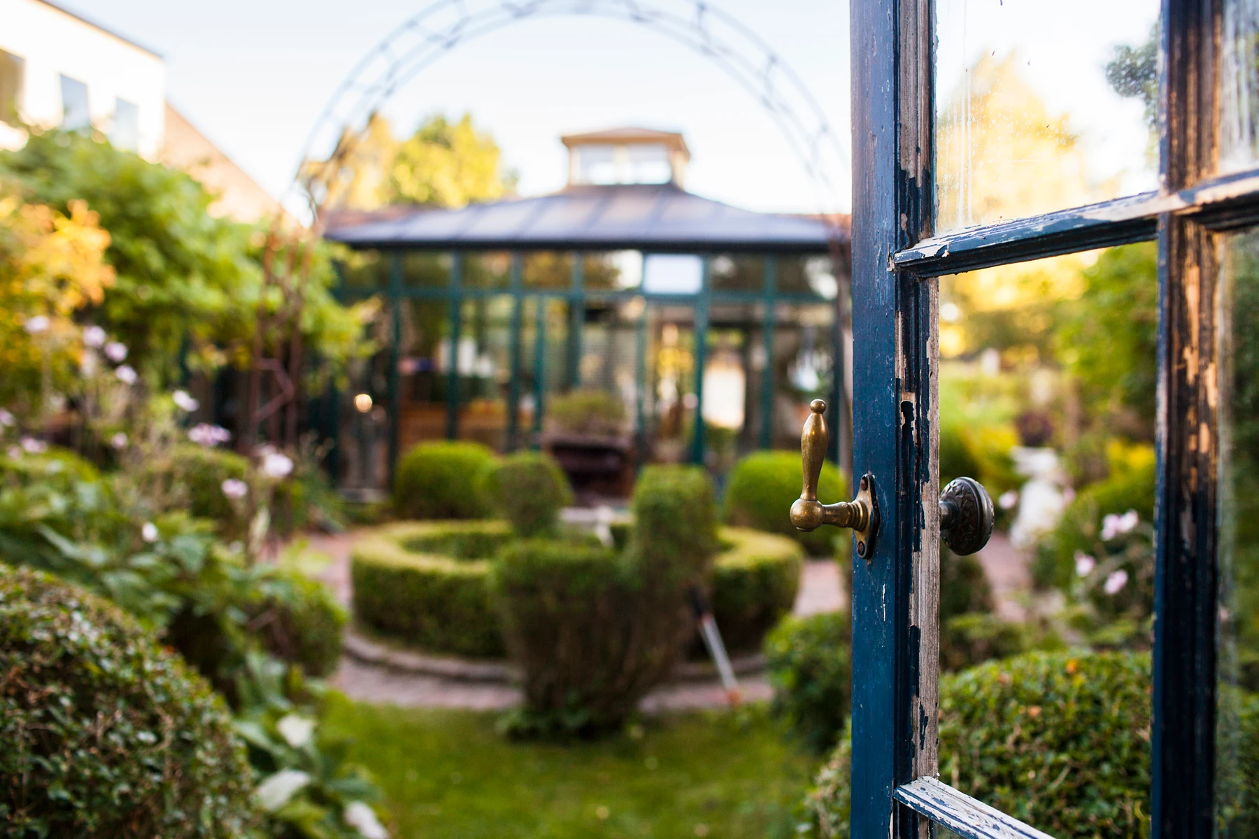 Blick auf einen schönen Garten durch eine offene Tür