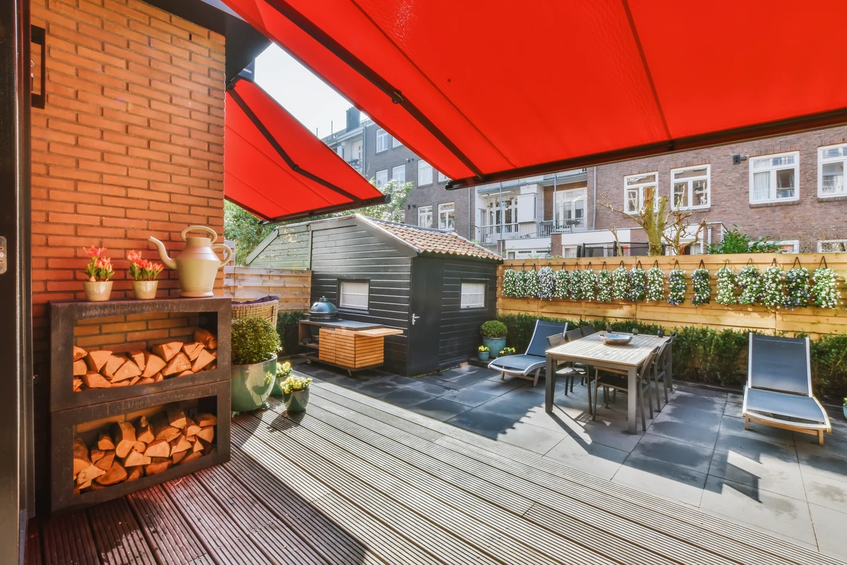 Terrasse mit Sonnenschirmen, Gartenmöbeln und Holzlager, ideal für Renovierung