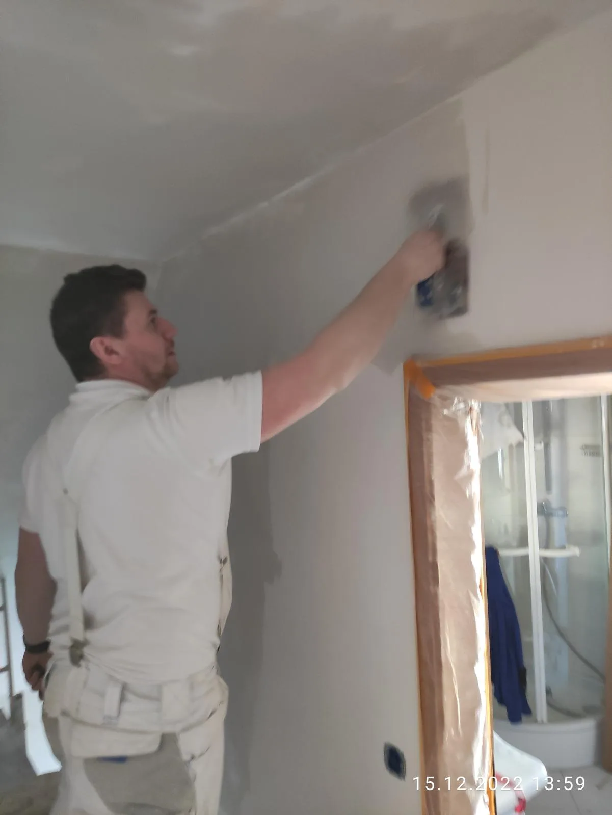 Ein Maler arbeitet an der Wand und bereitet den Innenausbau vor