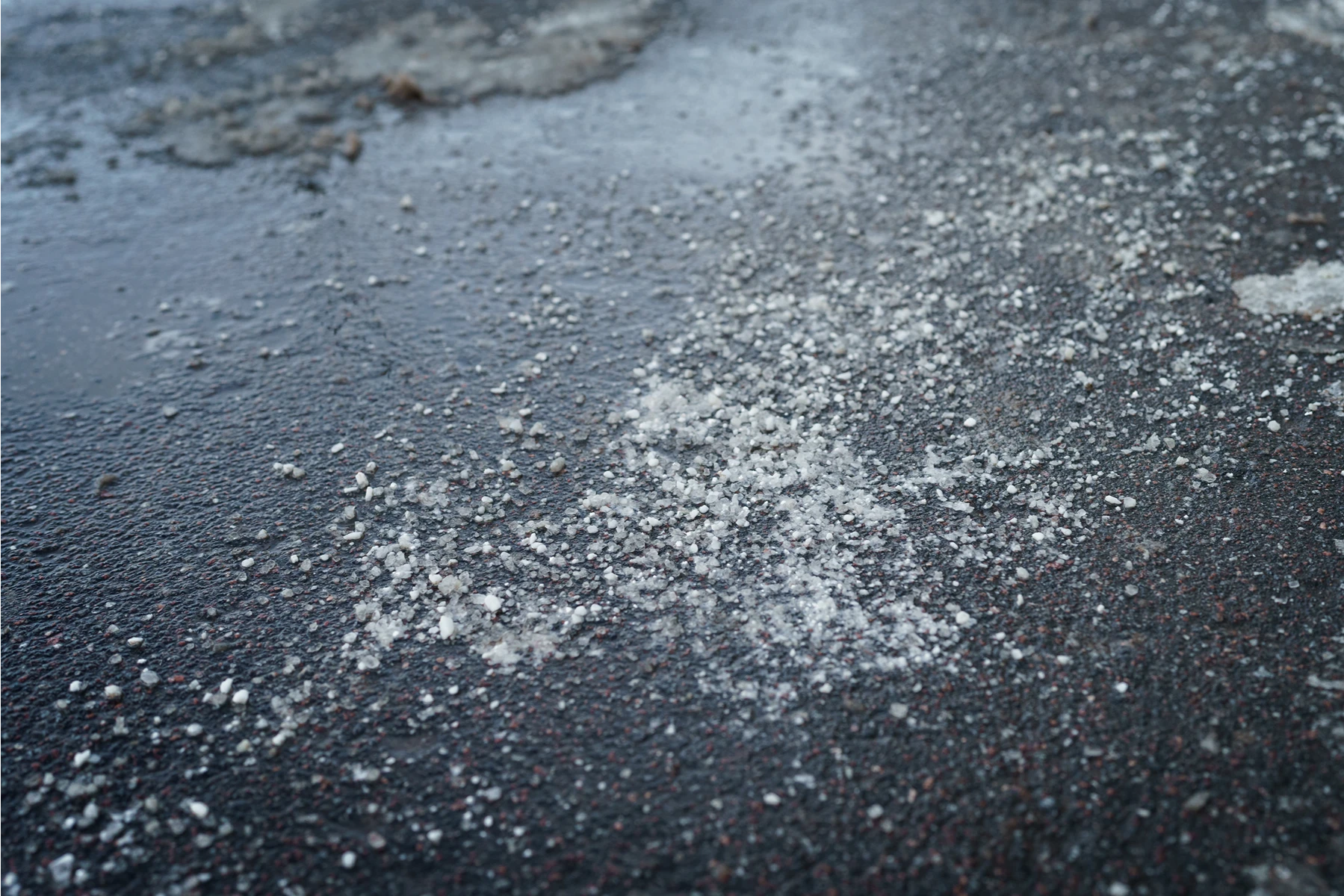Streudienst mit Salz auf einer gefrorenen Fläche