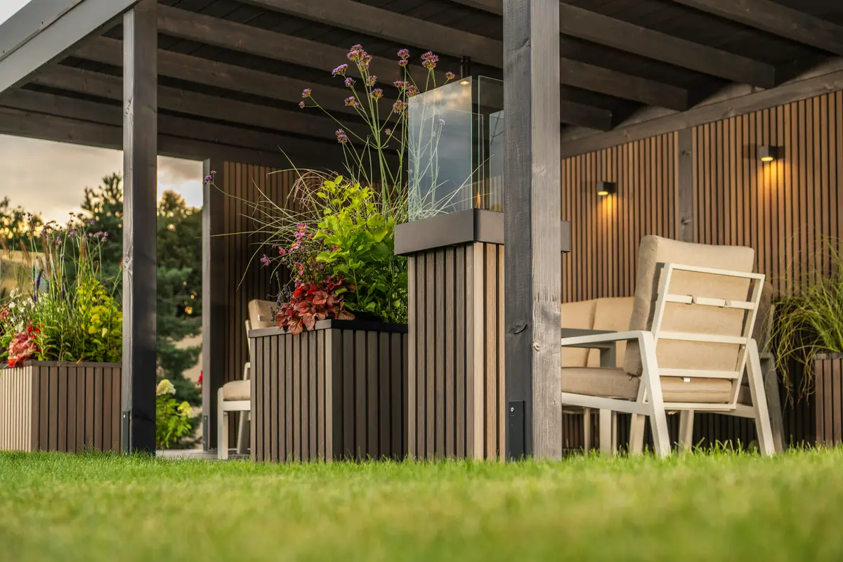 Gemütliche Terrasse mit modernen Möbeln und bepflanzten Trennwänden
