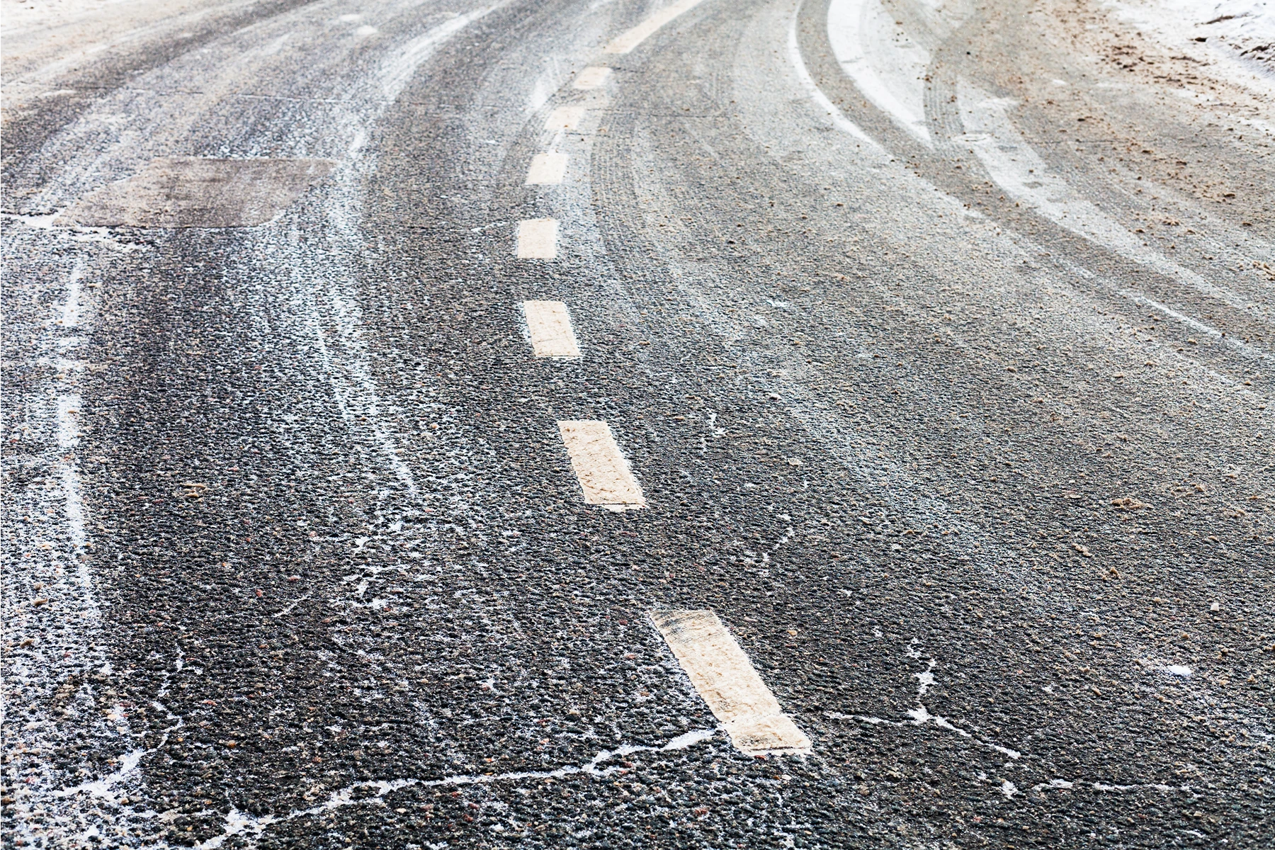 Schneebedeckte Straße mit sichtbaren Fahrbahnmarkierungen für den Winterdienst